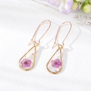 Handmade teardrop resin earrings with purple dried flowers and gold leaf accents