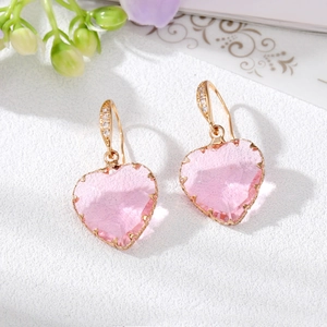 Boucles d'oreilles cœur en cristal rose doré avec zircons sur présentoir blanc élégant