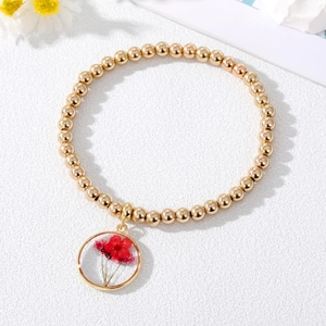Incantevole bracciale a sfere dorate con ciondolo rotondo contenente un vero fiore secco rosso