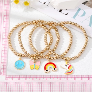 Set of four gold beaded bracelets featuring colorful smiley, butterfly, and unicorn charms