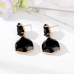 Close-up of geometric fan-shaped earrings with black crystal stones and gold plating
