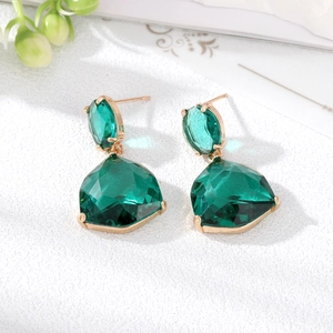 Detailed close-up of emerald green teardrop crystal earrings in gold-tone setting