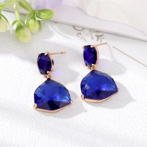 Macro shot of deep blue faceted crystal drop earrings with rose gold setting detail