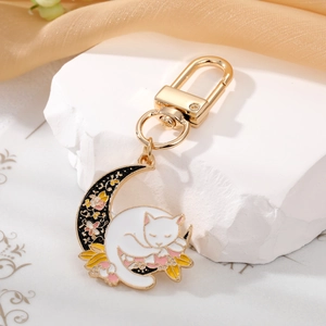 Cute enamel keychain featuring a white sleeping cat on a moon with colorful flowers
