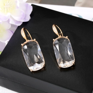 Vue macro détaillée des boucles d'oreilles en cristal carré avec zircons pavés en or