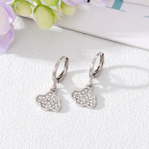 Sparkling silver cloud earrings with pavé zircons on a white textured background