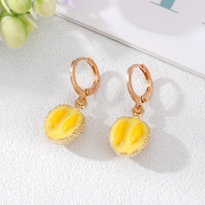 Détail de boucles d'oreilles durian créatives avec texture métal doré et pulpe en émail jaune