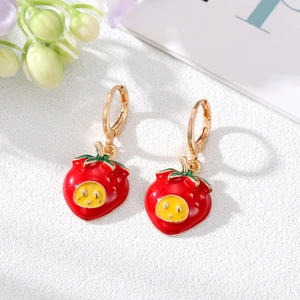Boucles d'oreilles fraises dorées avec sourires jaunes et détails de feuilles vertes