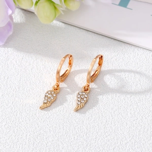 Close-up of golden angel wing drop earrings with sparkling pavé cubic zirconia