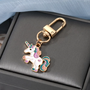 Detail eines weißen Einhorn-Anhängers mit bunter Mähne und goldenem Karabinerverschluss