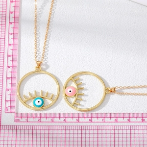 Mesure détaillée du pendentif œil maléfique doré de 3,2 cm avec cils sur une règle