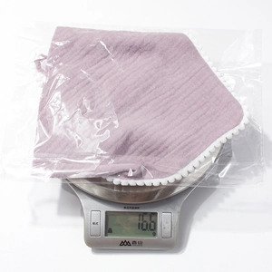 Macro detail of breathable light purple cotton gauze baby bib weighing 16.6 grams