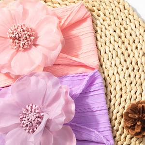 Gros plan de bandeaux bébé roses et violets avec fleurs en mousseline sur maille