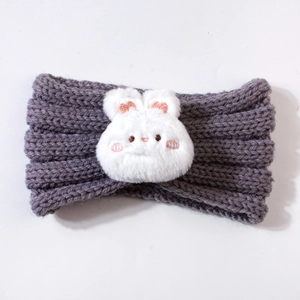 Macro detail of purple knit baby headband with a plush white cartoon bunny rabbit charm