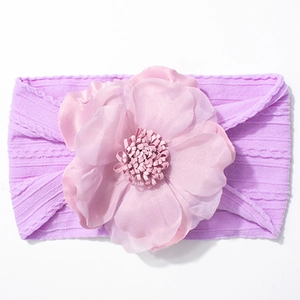 Détail du bandeau bébé en maille violette avec une grande fleur rose en tissu