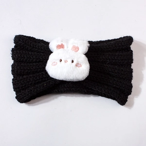 Close-up of black knitted baby headband featuring a cute white plush bunny accessory