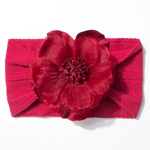 Détail du bandeau bébé bordeaux avec grande fleur en jacquard et texture en maille torsadée