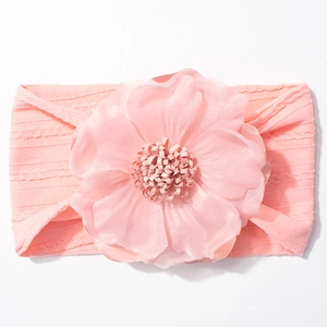 Détail d'un bandeau rose pour bébé avec grande fleur double en mousseline sur bande tricot