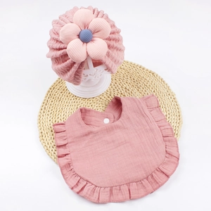 Set cappello e bavaglino rosa per neonati con fiore 3D su sfondo intrecciato