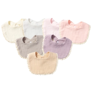 Detailed macro view of seven colorful cotton gauze baby bibs with lace edges and snap button
