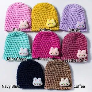 Detail of multi-color knitted baby hats with cute 3D bunny decor and thick knit texture
