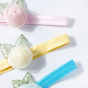Close-up of baby elastic headbands with 3D mesh roses in pink, yellow, and blue colors