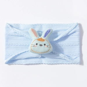 Detail of baby elastic headband in light blue rib knit fabric with a cute 3D bunny ornament