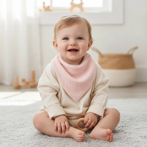 Close-up of soft pink muslin cotton baby bib with snap button worn by infant
