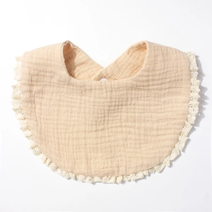 Close-up of soft cotton gauze baby bib with delicate white lace trim on white background