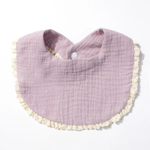 Detail of soft cotton gauze baby bib with elegant lace trim and secure snap button