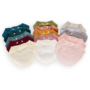 Detailed view of colorful cotton muslin baby bibs with double snap fasteners and texture