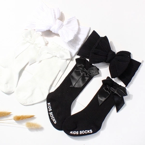 Close-up of baby socks and headbands set with double bows and delicate lace trim