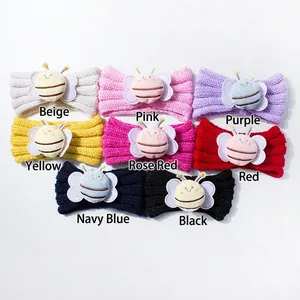Flat lay detail showing 8 colors of knitted baby headbands with 3D bee decorations