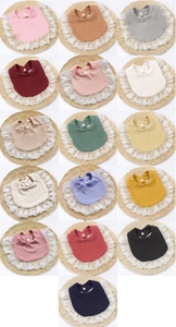 Detail showing various colors of cotton rib baby bibs with delicate white lace trim