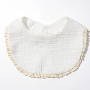Close-up of white cotton gauze baby bib with lace trim and snap button detail