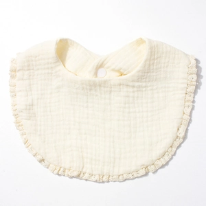 Detail of baby cotton gauze bib featuring elegant lace edges and soft muslin texture