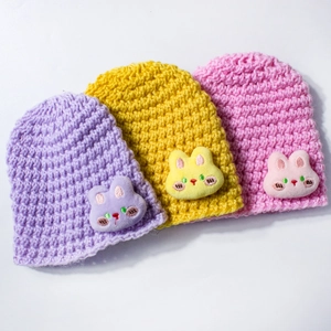 Detail of baby knitted hats featuring cute plush rabbit ears and embroidery details