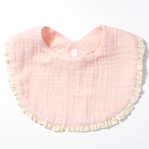 Detailed view of pink cotton gauze baby bib with delicate lace trim and white snap button