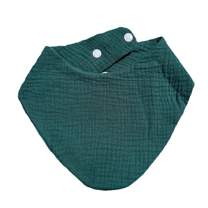 Close-up of dark green double-layer muslin cotton baby bib with white snap fasteners
