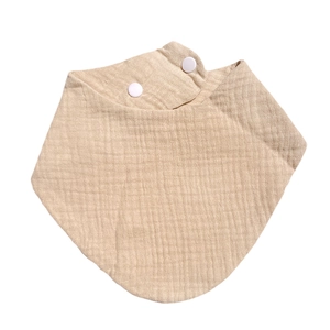 Detail view of khaki cotton gauze baby bib featuring soft texture and two plastic snap buttons