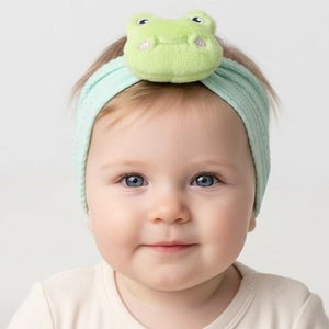 Close-up of a soft green knitted baby headband featuring a 3D plush frog decoration