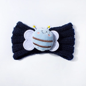 Detailed macro view of navy blue knitted baby headband featuring a soft plush bee mascot