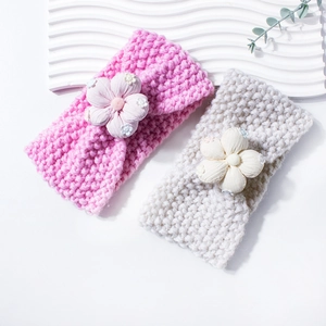 Detail of pink and beige knitted baby headbands featuring 3D floral embroidery appliques