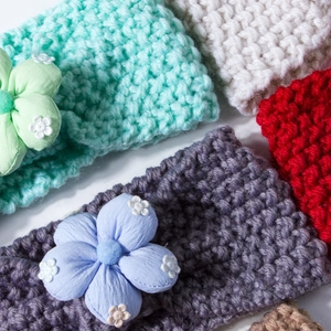 Detail of crochet baby headbands with knit texture and large fabric floral decorations