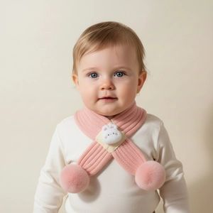 Detail of pink knitted baby scarf featuring plush pom-poms and a cute 3D bunny decor