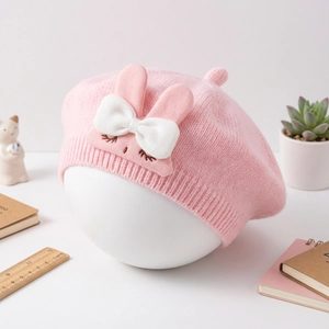 Detail of pink knit baby beret with 3D rabbit ears, white bow and cute eyelash embroidery