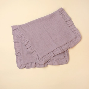Close-up of soft purple muslin cotton baby bib with decorative ruffled edge texture