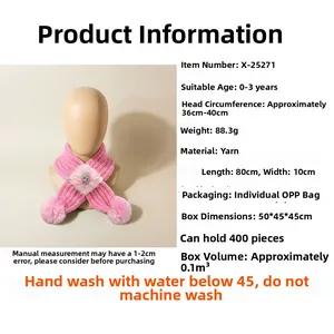 Détail d'une écharpe en tricot rose pour bébé avec fleur et pompon doux et chaud