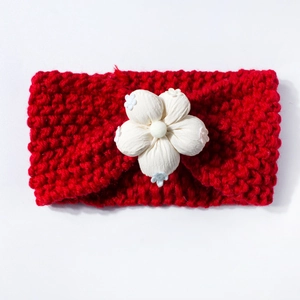Close-up of red knitted baby headband featuring a 3D white cotton flower detail