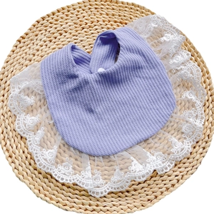 Detailed macro view of purple waffle cotton baby bib with delicate white lace edges